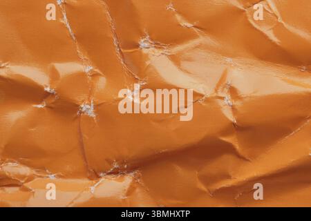Orange crumpled paper background with folds texture Stock Photo