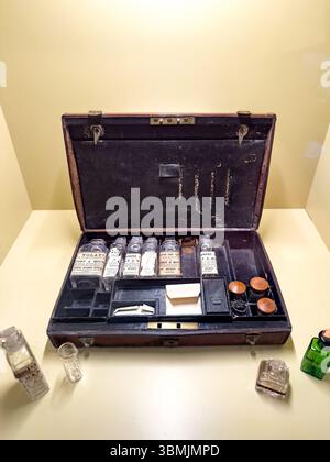 Vintage apothecary kit with glass bottles and cork stoppers displayed on a light brown table in a museum setting Stock Photo