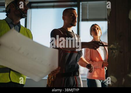 Team of construction professionals collaborating on a project inside a modern building Stock Photo