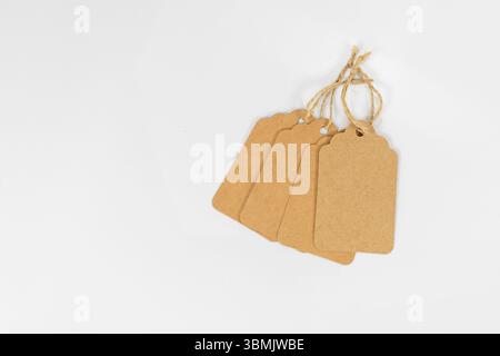 Group of Four Kraft Paper Tags Tied Together with Twine Isolated on White Background Stock Photo