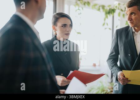 Business professionals discussing over documents in a modern office setting Stock Photo