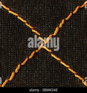 Seamless 4k photo texture of dark brown colored cotton tarpaulin material with orange cross stitching. Stock Photo