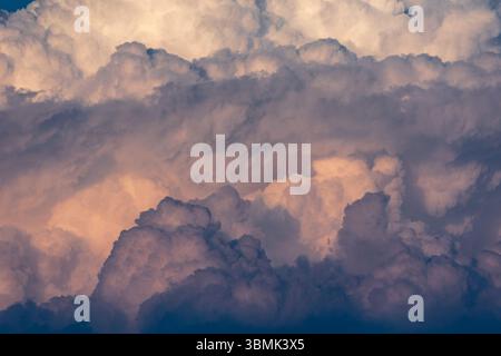 Closeup abstract image of big fluffy clouds in the sky with blue and orange hues and texture Stock Photo