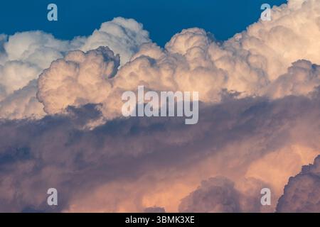 Closeup abstract image of big fluffy clouds in the sky with blue and orange hues and texture Stock Photo