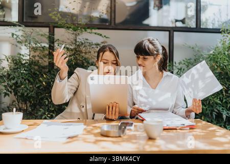 Two Engaged Young Professionals Collaborating at an Outdoor Office Desk Stock Photo