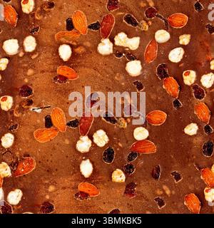 Seamless 4k photo texture of chocolate with hazelnuts and raisins. Stock Photo