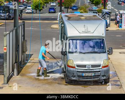 Man using a water jet to clean his horse box transporter - Loches, Indre-et-Loire (37), France. Stock Photo