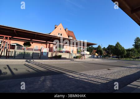 WASSERBURG AM INN, GERMANY - JUNE 20, 2025: Wide-angle view of the bus station in Wasserburg am Inn with wooden shelters and residential buildings in Stock Photo