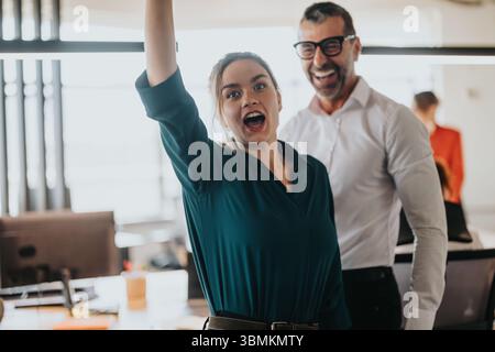Excited business professionals celebrating success in modern office environment Stock Photo