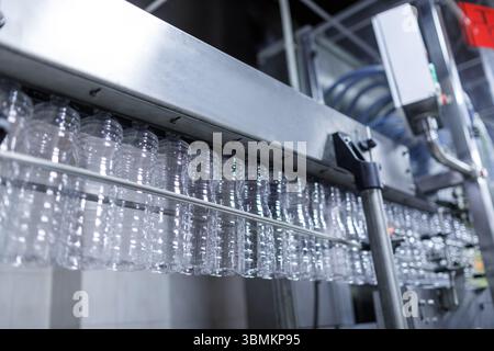 Plastic bottle production line in a modern factory with empty containers on automated conveyor ready for filling Stock Photo