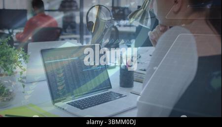 Analyzing financial data with image, businesswoman using laptop in office Stock Photo