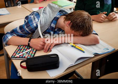 Netherlands, Arnhem. Pupil is tired and sleeps while in class. Stock Photo