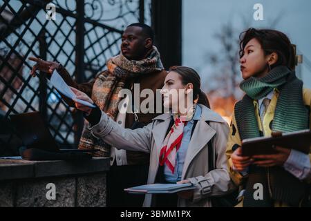 Multiracial people gathered outdoors discussing documents in a business meeting Stock Photo