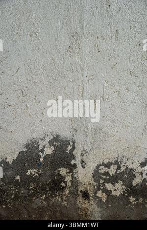 Wall with a lot of cracks and peeling paint. The wall is grey and has a rough texture perfect for 3d texture and material Stock Photo