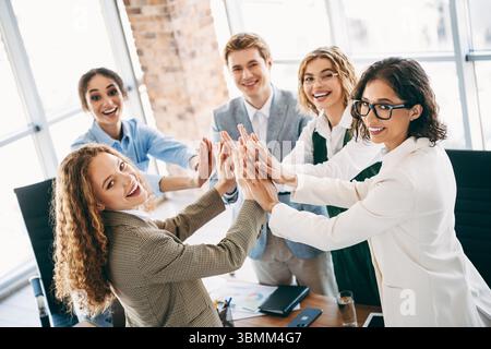 Professional team of young business colleagues collaborating in an office workspace, engaging in teamwork and building partnerships Stock Photo