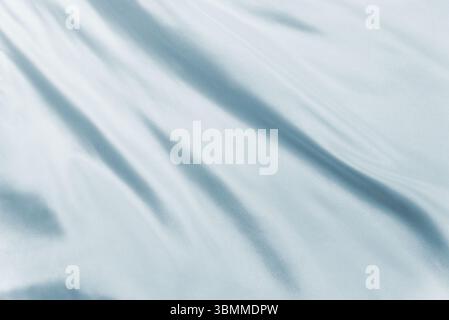 Soft white silk waving in natural light, ideal for elegant textures, minimalist backgrounds, or product mockups in high-end design Stock Photo