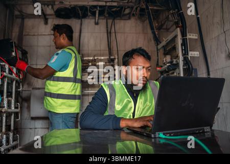 Technician and engineer team fixing network devices, routers, configuring servers, and repairing cables in network room. IT maintenance Stock Photo