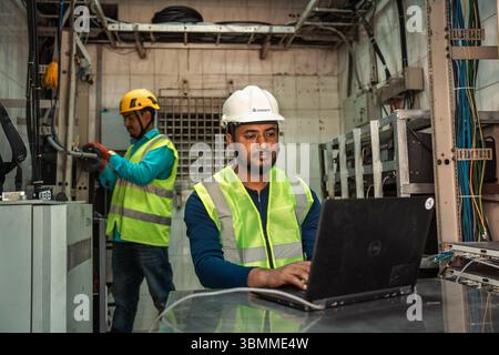 Technician and engineer team fixing network devices, routers, configuring servers, and repairing cables in network room. IT maintenance Stock Photo