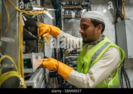 Technician and engineer team fixing network devices, routers, configuring servers, and repairing cables in network room. IT maintenance Stock Photo