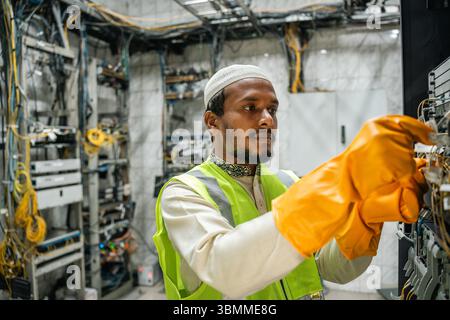 Technician and engineer team fixing network devices, routers, configuring servers, and repairing cables in network room. IT maintenance Stock Photo