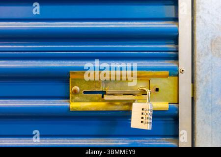 Combination lock securing door on self storage unit. Stock Photo