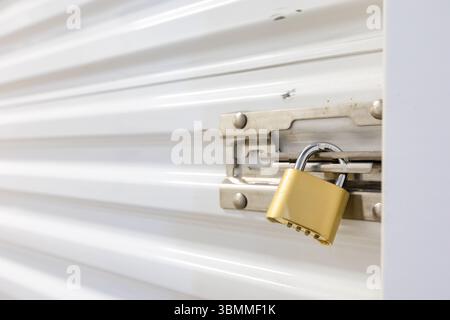 Combination lock securing door on self storage unit. Stock Photo