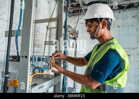 Technician and engineer team fixing network devices, routers, configuring servers, and repairing cables in network room. IT maintenance Stock Photo