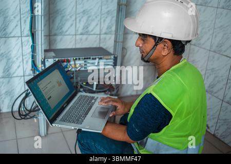 Technician and engineer team fixing network devices, routers, configuring servers, and repairing cables in network room. IT maintenance Stock Photo