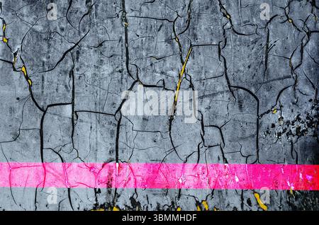 Abstract veiw of old cracked gray paint on black and yellow base with a faded red horizontal stripe Stock Photo