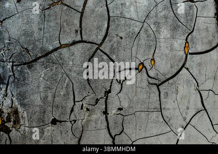 Close-up Abstract veiw of old cracked gray paint on black and yellow base Stock Photo
