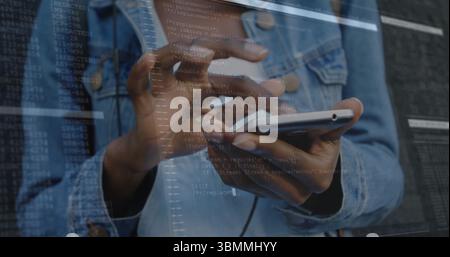 Tapping developer hands in denim jacket on phone touchscreen at tech workspace, with code overlay Stock Photo