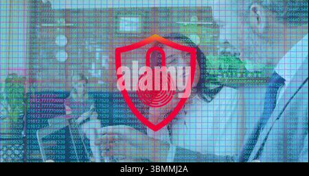 Walking team wearing suits, carrying tablet in office hall, showing red shield icon over code grid Stock Photo