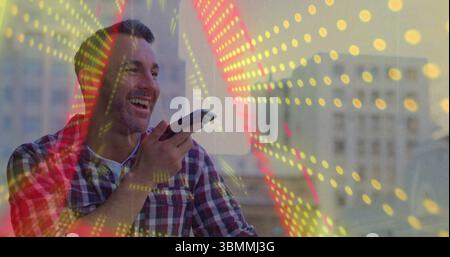 Speaking middle-aged man wearing plaid shirt holding smartphone on rooftop, with digital overlay Stock Photo