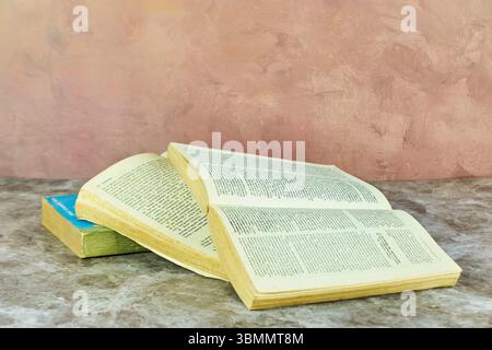 Stack of books on a marble table. Collection of different books. Hardcover books for reading. Book reading concept. Stock Photo
