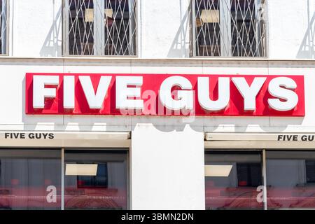 The sign of the popular American burger restaurant Five Guys on a building in the city center. Austria, Vienna, June 27, 2025. Stock Photo