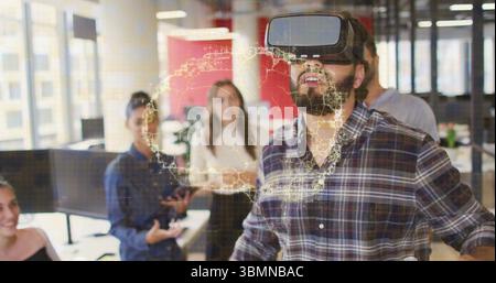 Demonstrating man wearing VR headset interacting with holographic world map in office, with tablet Stock Photo