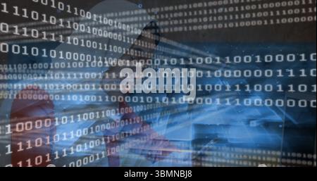 Sitting woman focusing on laptop at office desk with red chair, smartphone and binary code overlay Stock Photo