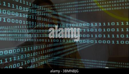 Typing woman coding at home desk, with laptop, over-ear headphones, glasses, binary graph overlay Stock Photo