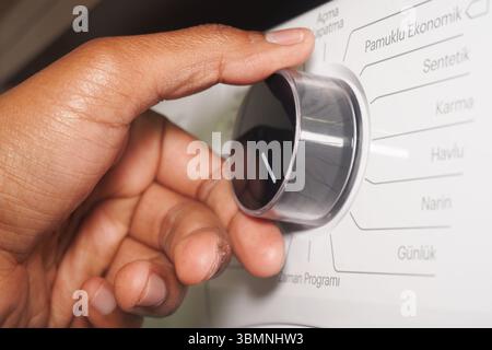 Adjusting the settings on a washing machine at home Stock Photo