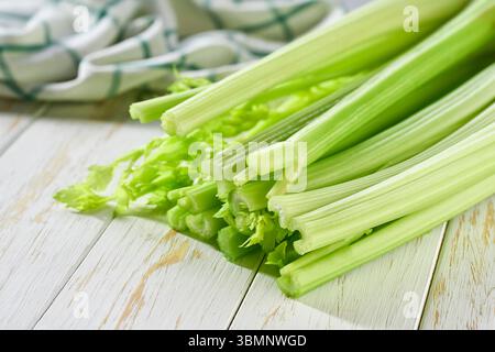 Celery stems and leaves on wooden table, selective focus. Stock Photo