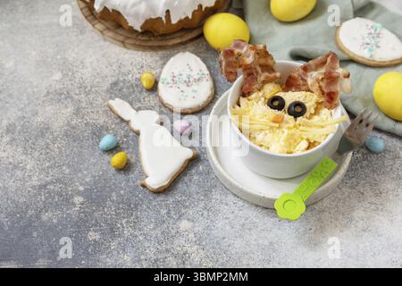 Easter breakfast idea. Scrambled eggs easter bunny on a stone background. Copy space Stock Photo