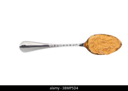 peanut creamy paste in a metal spoon isolated on white background,top view. Delicious peanut butter in spoon. Stock Photo