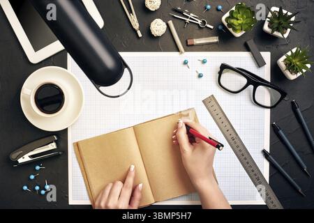 Concept architects. Architects workplace, architectural project, blueprints, ruler. Engineer holds a pen and writes in a notebook. Equipment architect Stock Photo
