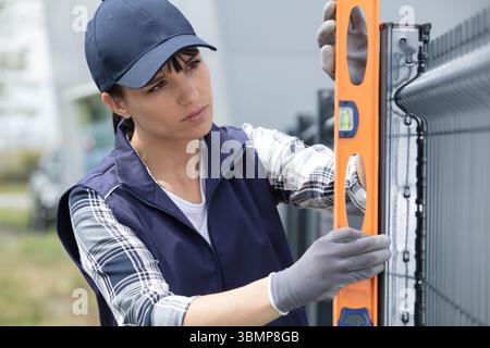 female builder using a spirit level Stock Photo