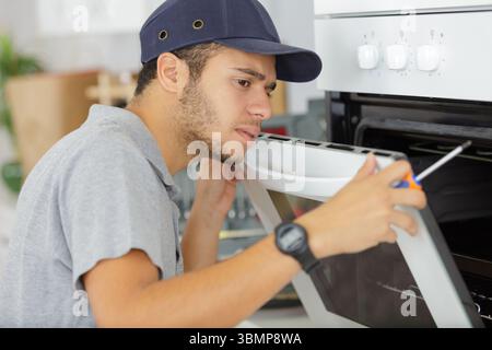 young male worker installing new oven Stock Photo