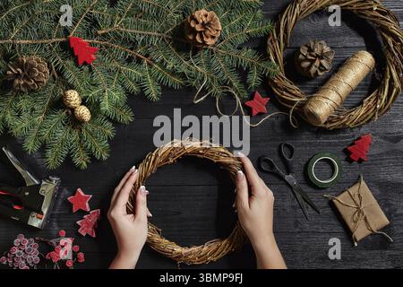 Manufacturer of Christmas decor with their own hands. Christmas wreath for the holiday. The new year celebration. Master class on making decorative or Stock Photo