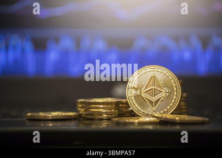 Golden bitcoin are stacked on a bright background of business graphs close-up. Bitcoin cryptocurrency Stock Photo