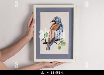 Woman holding in hands mosaic picture in a frame. Close-up Stock Photo