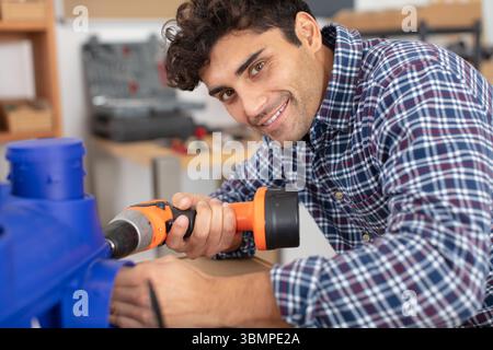 handsome young man holding drilling machine Stock Photo