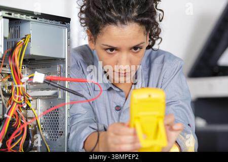 female technician using voltage meter for voltage measurement Stock Photo